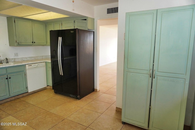 100 N Dale Rd, Pearce, AZ 85625 - kitchen with dishwasher, freestanding refrigerator, green cabinets, light countertops, and light tile patterned floors