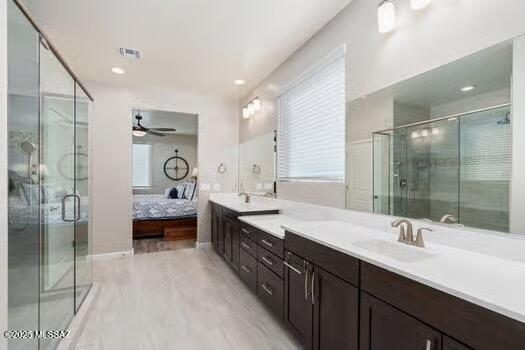 11815 N Silverscape Dr, Oro Valley, AZ 85737 - ensuite bathroom with a ceiling fan, double vanity, healthy amount of natural light, and a shower stall