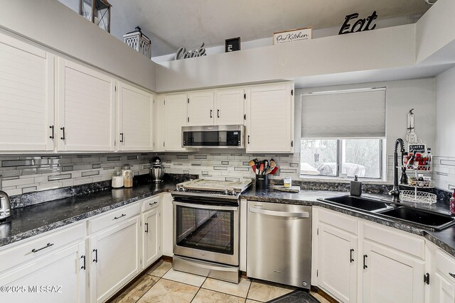 9650 N Gyor Pl, Tucson, AZ 85742 - kitchen with appliances with stainless steel finishes, a sink, decorative backsplash, light tile patterned floors, and white cabinetry
