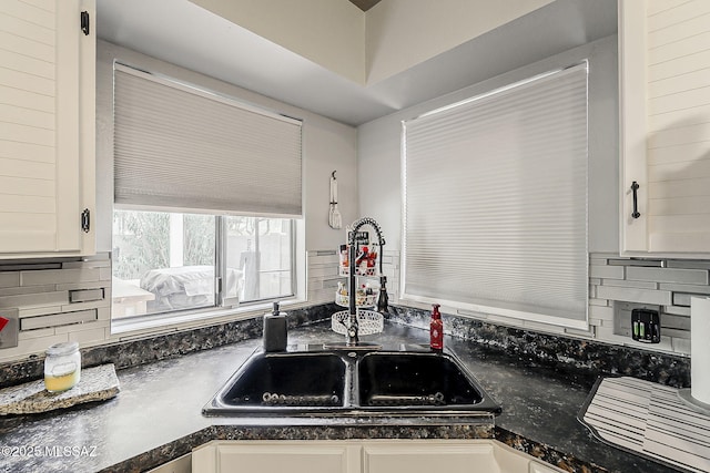 9650 N Gyor Pl, Tucson, AZ 85742 - kitchen featuring a sink, dark countertops, decorative backsplash, and white cabinets