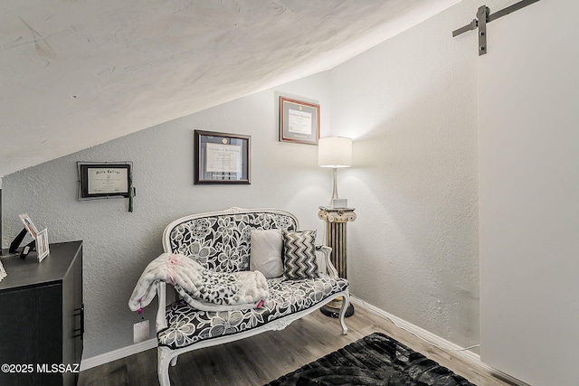 9650 N Gyor Pl, Tucson, AZ 85742 - sitting room with vaulted ceiling, wood finished floors, a barn door, and baseboards