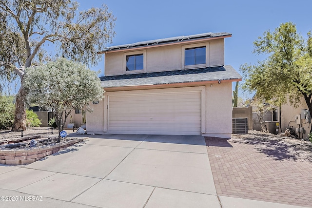 9650 N Gyor Pl, Tucson, AZ 85742 - traditional-style house featuring stucco siding, concrete driveway, a garage, roof mounted solar panels, and cooling unit