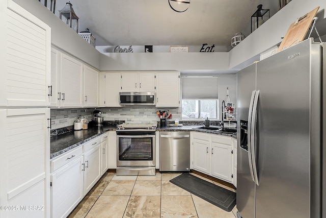 9650 N Gyor Pl, Tucson, AZ 85742 - kitchen with stainless steel appliances, dark countertops, white cabinets, a sink, and decorative backsplash