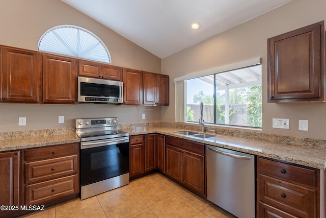 9701 N Camino Del Fierro, Tucson, AZ 85742 - kitchen with stainless steel appliances, a sink, lofted ceiling, light tile patterned floors, and light stone countertops