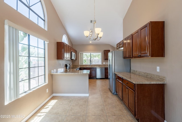 9701 N Camino Del Fierro, Tucson, AZ 85742 - kitchen featuring stainless steel appliances, a chandelier, light tile patterned flooring, a peninsula, and hanging light fixtures
