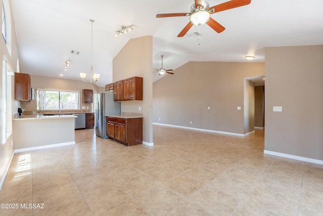 9701 N Camino Del Fierro, Tucson, AZ 85742 - kitchen with stainless steel appliances, a ceiling fan, open floor plan, vaulted ceiling, and brown cabinetry