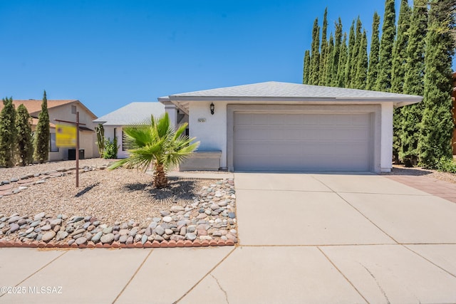 9701 N Camino Del Fierro, Tucson, AZ 85742 - view of front facade featuring a garage, stucco siding, and concrete driveway