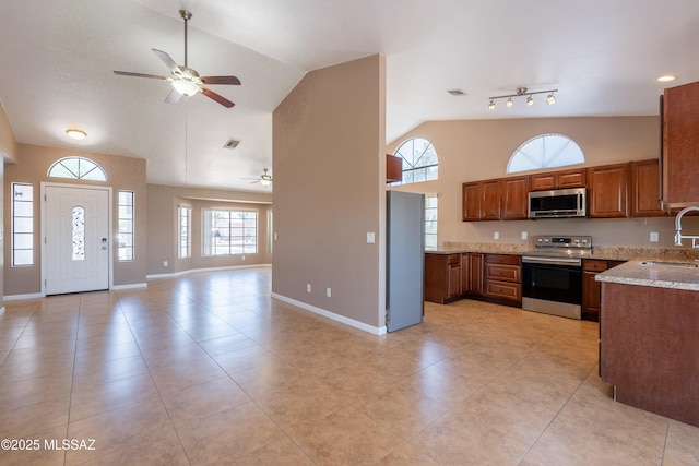 9701 N Camino Del Fierro, Tucson, AZ 85742 - kitchen featuring appliances with stainless steel finishes, a sink, a ceiling fan, open floor plan, and high vaulted ceiling