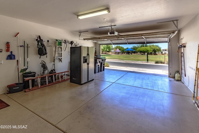 19 W Via Teresita, Sahuarita, AZ 85629 - garage featuring stainless steel fridge with ice dispenser and a garage door opener