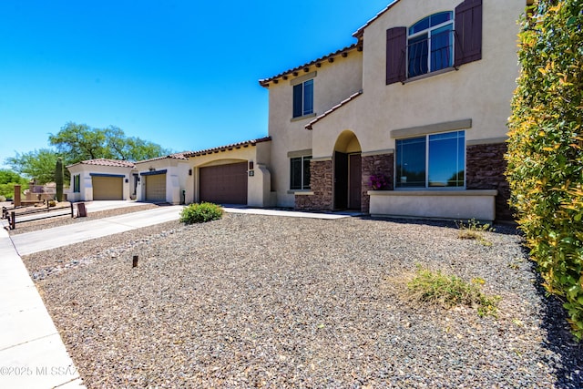 19 W Via Teresita, Sahuarita, AZ 85629 - mediterranean / spanish home featuring stucco siding, driveway, stone siding, a garage, and a tiled roof