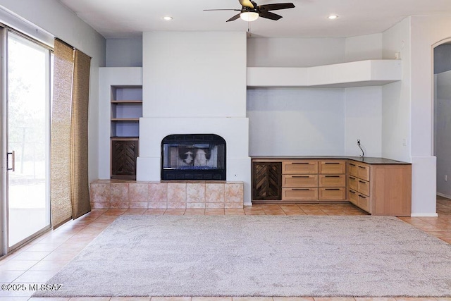 161 N Carlilse Way, Willcox, AZ 85643 - unfurnished living room featuring healthy amount of natural light, light tile patterned floors, a ceiling fan, a tile fireplace, and recessed lighting