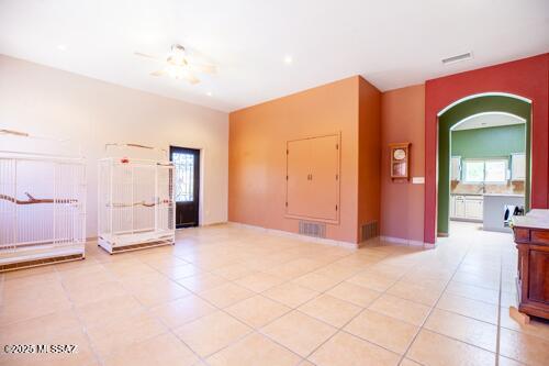 480 Camino Ramanote, Rio Rico, AZ 85648 - unfurnished room featuring light tile patterned floors, arched walkways, healthy amount of natural light, and baseboards
