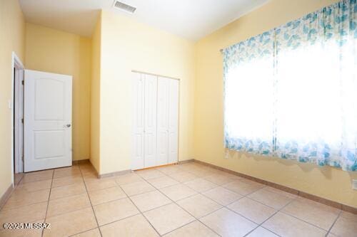 480 Camino Ramanote, Rio Rico, AZ 85648 - unfurnished bedroom featuring a closet, light tile patterned floors, and baseboards