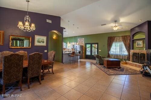 480 Camino Ramanote, Rio Rico, AZ 85648 - dining area featuring a chandelier, a ceiling fan, a fireplace with raised hearth, tile patterned flooring, and arched walkways