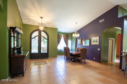 480 Camino Ramanote, Rio Rico, AZ 85648 - foyer entrance with arched walkways, a chandelier, french doors, high vaulted ceiling, and light tile patterned flooring