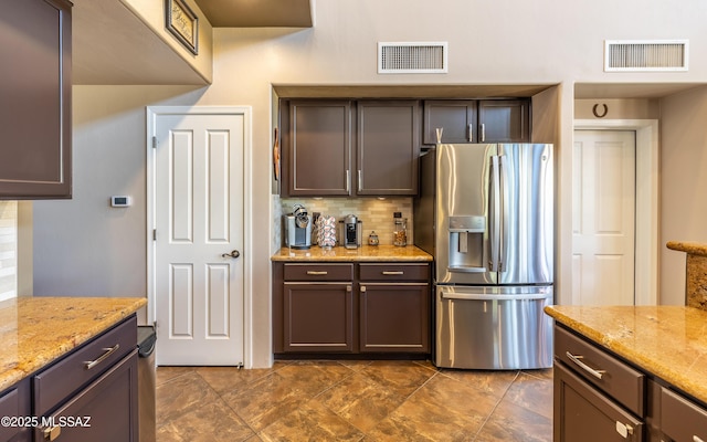 9387 S Via Famero, Vail, AZ 85641 - kitchen with stainless steel refrigerator with ice dispenser, decorative backsplash, light stone countertops, and dark brown cabinets