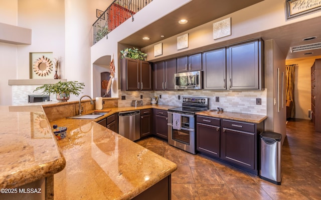 9387 S Via Famero, Vail, AZ 85641 - kitchen featuring appliances with stainless steel finishes, a sink, arched walkways, light stone countertops, and decorative backsplash