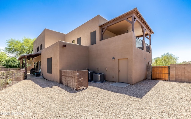 9387 S Via Famero, Vail, AZ 85641 - back of property with stucco siding, a gate, cooling unit, and a ceiling fan