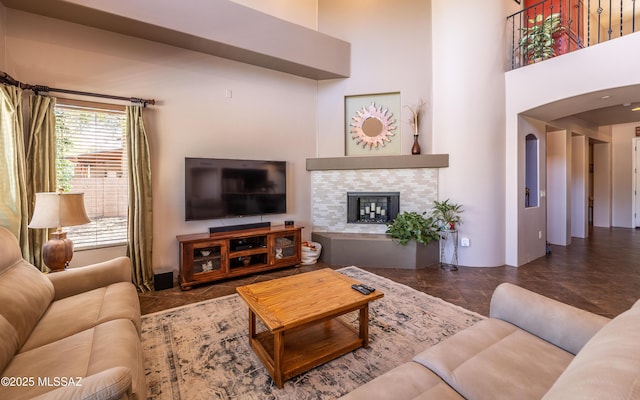 9387 S Via Famero, Vail, AZ 85641 - living room with arched walkways, a tiled fireplace, and a high ceiling