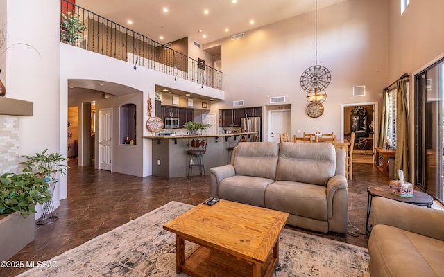 9387 S Via Famero, Vail, AZ 85641 - living area with a chandelier, arched walkways, a high ceiling, and recessed lighting