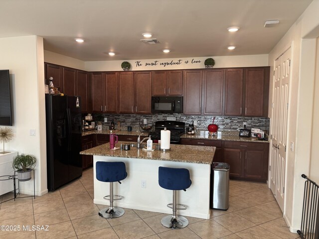 10822 E Franklin Falls Way, Vail, AZ 85641 - kitchen featuring black appliances, a kitchen breakfast bar, decorative backsplash, and stone countertops