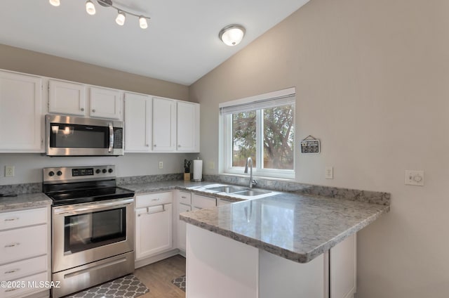 11561 N Eagle Peak Dr, Oro Valley, AZ 85737 - kitchen featuring stainless steel appliances, a sink, a peninsula, lofted ceiling, and white cabinets