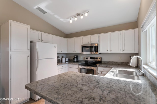 11561 N Eagle Peak Dr, Oro Valley, AZ 85737 - kitchen with stainless steel appliances, a sink, lofted ceiling, a peninsula, and white cabinets
