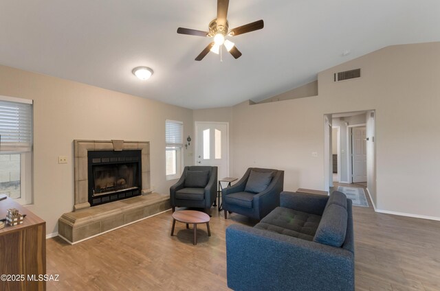 11561 N Eagle Peak Dr, Oro Valley, AZ 85737 - living room featuring a ceiling fan, vaulted ceiling, wood finished floors, a tiled fireplace, and baseboards