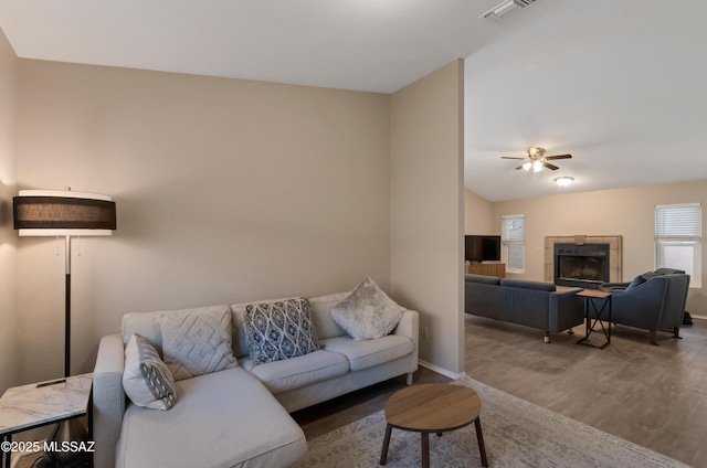 11561 N Eagle Peak Dr, Oro Valley, AZ 85737 - living room with wood finished floors, a ceiling fan, baseboards, a tiled fireplace, and vaulted ceiling