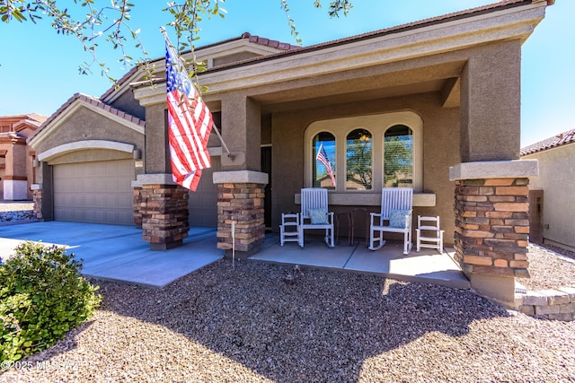 9978 N Niobrara Way, Tucson, AZ 85742 - view of front of property with stucco siding, a garage, a porch, stone siding, and a tiled roof