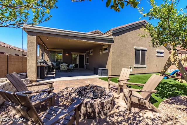 9978 N Niobrara Way, Tucson, AZ 85742 - back of property with a patio, stucco siding, a playground, an outdoor living space with a fire pit, and central AC unit