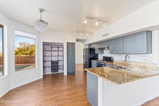 11262 N Chynna Rose Pl, Oro Valley, AZ 85737 - kitchen featuring stainless steel appliances, a sink, under cabinet range hood, light stone countertops, and light wood finished floors
