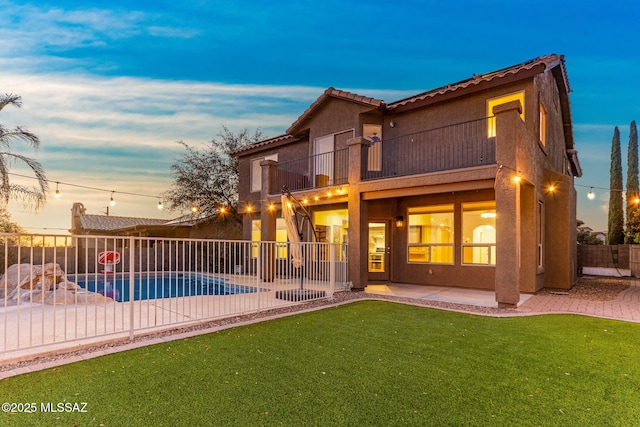 11262 N Chynna Rose Pl, Oro Valley, AZ 85737 - back of property at dusk with a balcony, a patio area, stucco siding, and a tile roof