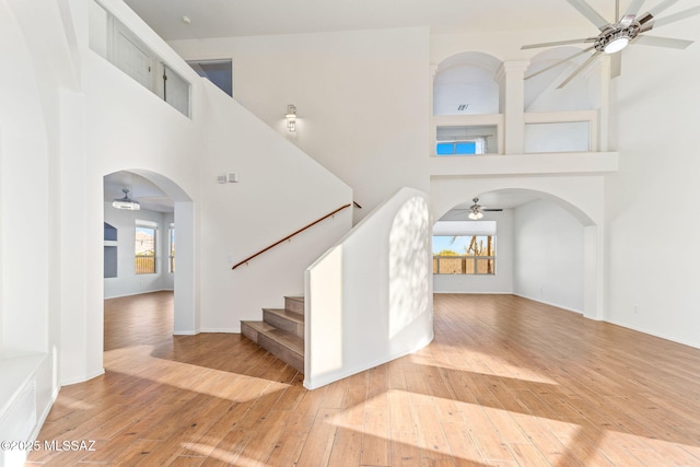11262 N Chynna Rose Pl, Oro Valley, AZ 85737 - stairs with ceiling fan, a high ceiling, hardwood / wood-style flooring, arched walkways, and baseboards