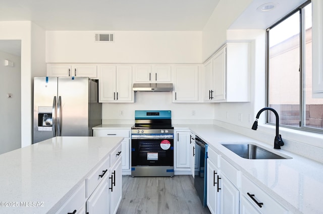185 E Calle Zavala, Tucson, AZ 85704 - kitchen with stainless steel appliances, a sink, under cabinet range hood, and white cabinetry