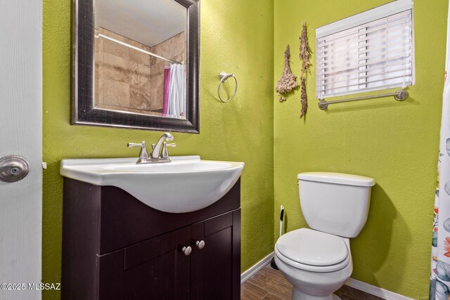 2113 N Belvedere Ave, Tucson, AZ 85712 - bathroom with vanity, toilet, wood finished floors, curtained shower, and baseboards