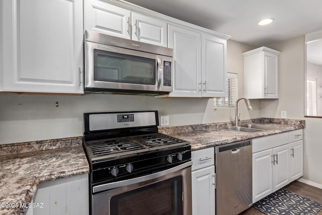 2113 N Belvedere Ave, Tucson, AZ 85712 - kitchen featuring appliances with stainless steel finishes, a sink, white cabinets, dark wood-type flooring, and recessed lighting