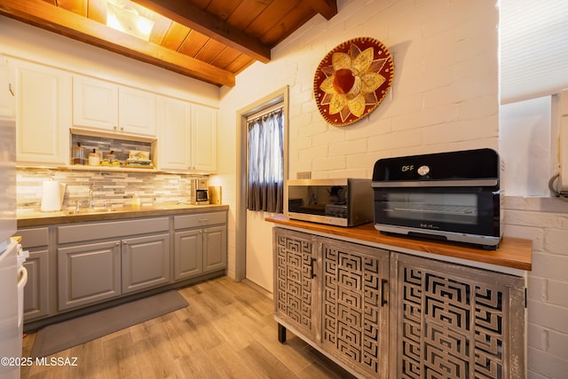 1912 E Water St, Tucson, AZ 85719 - kitchen with decorative backsplash, wood ceiling with exposed beams, light wood-style floors, white cabinetry, and gray cabinets