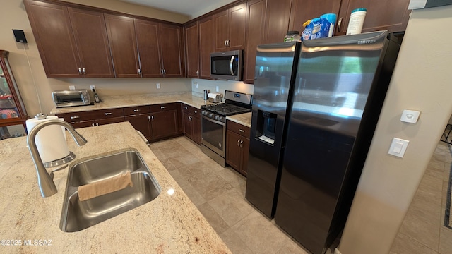 10218 S Hickory Wood Way, Vail, AZ 85641 - kitchen featuring stainless steel appliances, light stone countertops, dark brown cabinets, and a sink