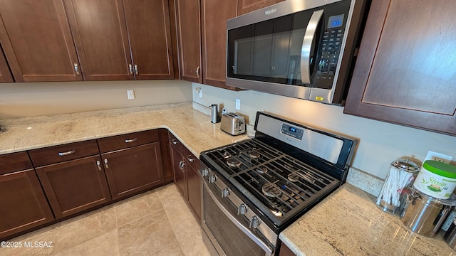 10218 S Hickory Wood Way, Vail, AZ 85641 - kitchen featuring stainless steel appliances, dark brown cabinets, light stone counters, and light tile patterned flooring