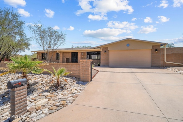 7302 E Rocky Creek Pl, Tucson, AZ 85750 - ranch-style home with a garage, driveway, and brick siding