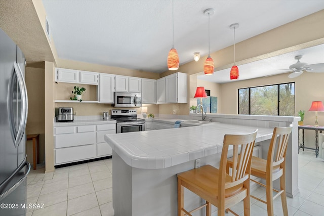 7302 E Rocky Creek Pl, Tucson, AZ 85750 - kitchen featuring appliances with stainless steel finishes, a sink, a peninsula, and light tile patterned floors