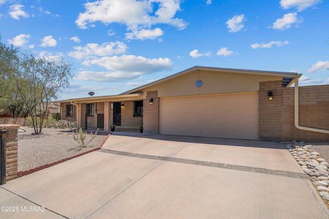7302 E Rocky Creek Pl, Tucson, AZ 85750 - ranch-style home with brick siding, a garage, concrete driveway, and covered porch