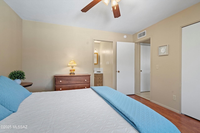 7302 E Rocky Creek Pl, Tucson, AZ 85750 - bedroom featuring wood finished floors, baseboards, ensuite bathroom, and a ceiling fan