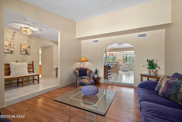 7302 E Rocky Creek Pl, Tucson, AZ 85750 - living room featuring arched walkways, wood finished floors, and baseboards