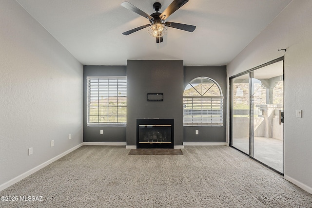 101 S Players Club Dr Unit 11204, Tucson, AZ 85745 - unfurnished living room featuring carpet floors, a ceiling fan, baseboards, and a fireplace with flush hearth