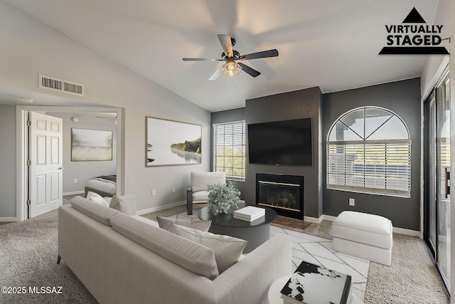 101 S Players Club Dr Unit 11204, Tucson, AZ 85745 - living area with a ceiling fan, a glass covered fireplace, vaulted ceiling, baseboards, and carpet