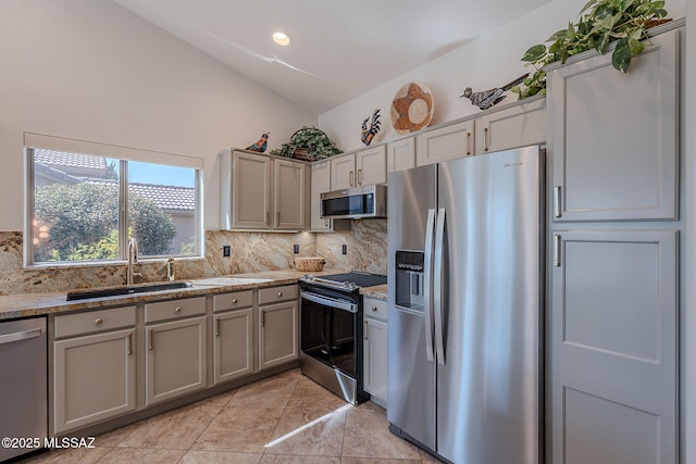 2136 E Desert Fox Dr, Green Valley, AZ 85614 - kitchen featuring stainless steel appliances, vaulted ceiling, a sink, decorative backsplash, and gray cabinets