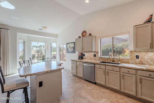 2136 E Desert Fox Dr, Green Valley, AZ 85614 - kitchen featuring stainless steel dishwasher, a sink, gray cabinetry, decorative backsplash, and a breakfast bar