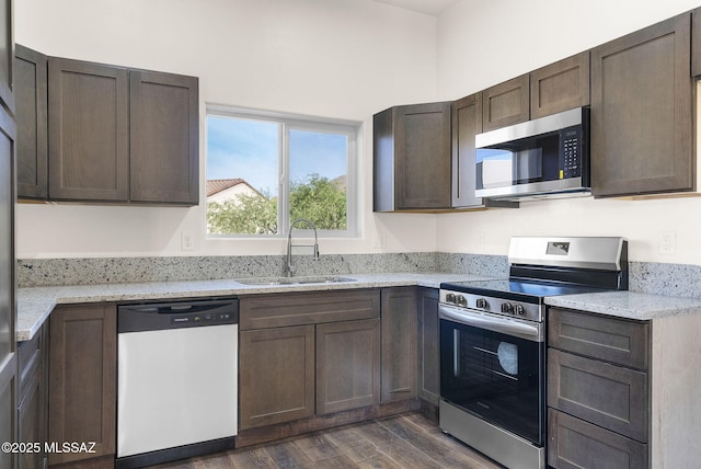 1801 Saltillo Ct, Rio Rico, AZ 85648 - kitchen with stainless steel appliances, a sink, dark wood-style floors, light stone countertops, and dark brown cabinetry